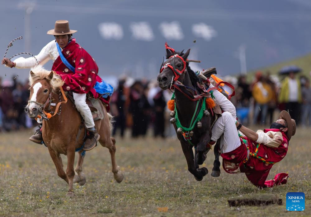 Seorang penunggang (kanan) mempamerkan kemahirannya di sebuah balapan lumba kuda di Kaunti Litang, Wilayah Autonomi Tibet Garz, Provinsi Sichuan, barat daya China pada 30 Julai 2024. Satu acara lumba kuda membuka tirainya di Kaunti Litang pada Selasa, menarik penyertaan hampir 1,000 pengembala dari serata kaunti dalam pelbagai aktiviti. (Xinhua/Jiang Hongjing)